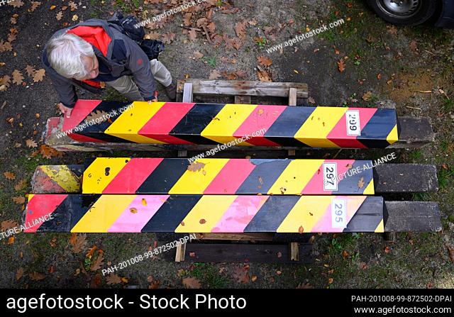 08 October 2020, Saxony, Bad Muskau: Holger Daetz, operations manager of the ""Fürst Pückler Park"" foundation, inspects old marking columns from GDR times in...