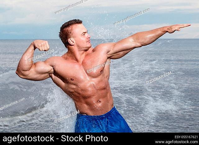 Sport, fitness. Bodybuilder with sexy body on the beach