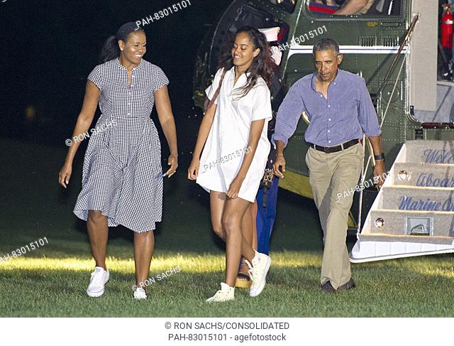 United States President Barack Obama, right, first lady Michelle Obama, left, and daughter Malia Obama, center, arrive on the South Lawn of the White House in...