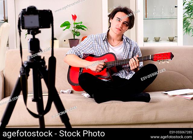Young guitar player recording video for his blog