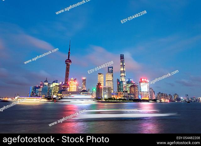 beautiful shanghai skyline in summer night, light trails from pleasure boat on huangpu river
