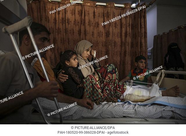 dpatop - Palestinian woman Asma Abu Daqah (2-R) and her husband Mohammed Abu Daqah (L) lie inside a hospital with their daughter Lian (2-L) and their son Omar...