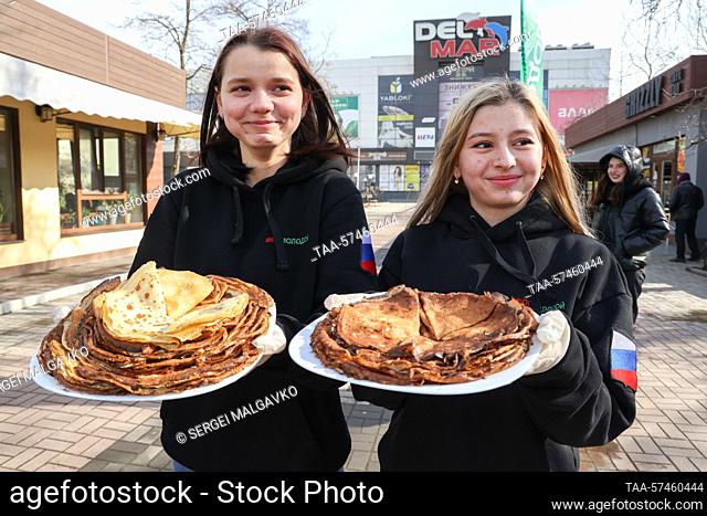 RUSSIA, BERDYANSK - FEBRUARY 20, 2023: Activists of the Young South public organization give out blini, traditional Russian pancakes
