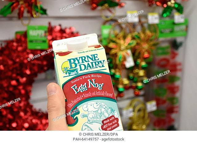 A person holds a carton of eggnog in a supermarket in New York, USA, 25 November 2015. The egg milk punch with rum is often served for Christmas in the United...