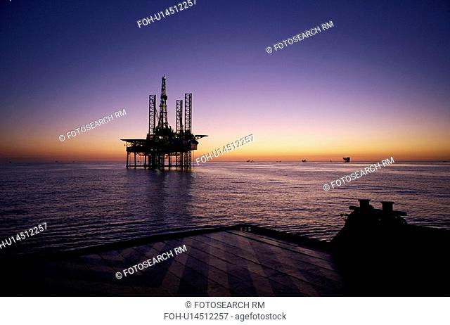 Silhouete View from Supply Boat of Offshore Oil Drilling Rig at Sunset