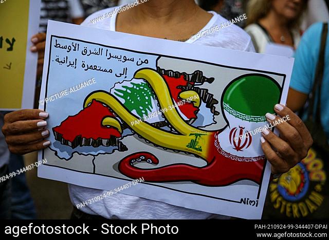 24 September 2021, Lebanon, Beirut: A woman holds an sign reading ""From the Switzerland of the Middle East to an Iranian Colony"" during a protest by members...