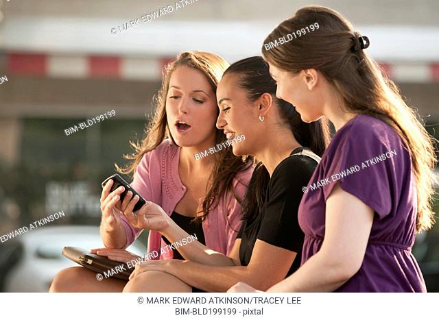 Woman showing cell phone to friends