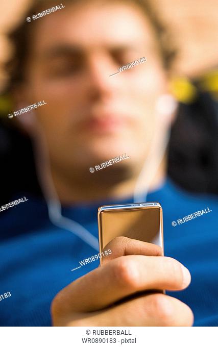 Close-up of a young man holding an MP3 Player