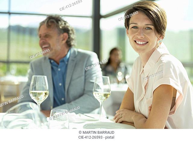Portrait smiling woman drinking wine in sunny restaurant