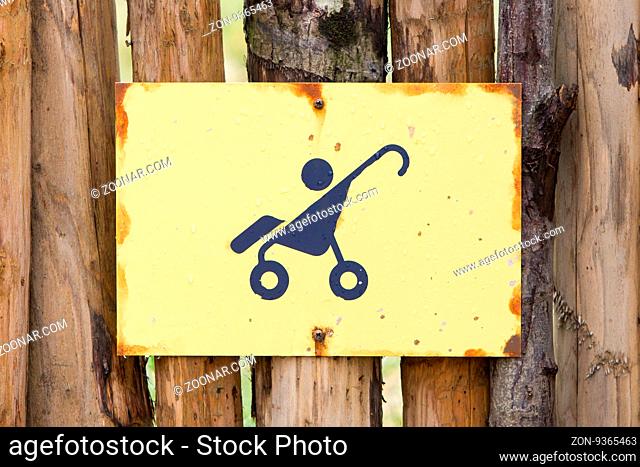 Baby stroller sign, hanging on a wooden fence