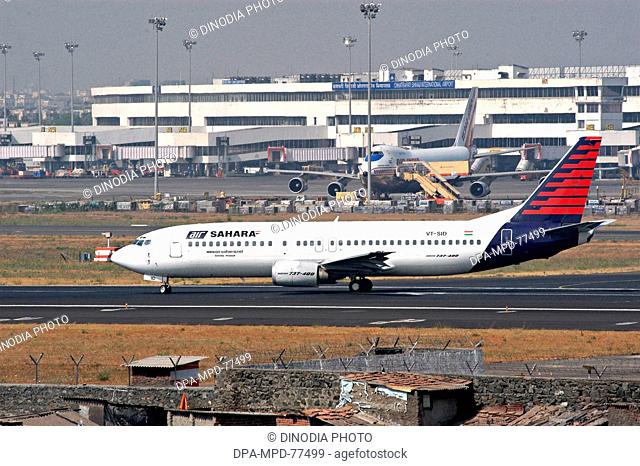 Aeroplane ; An Air-India plane standing at the Chhatrapati Shivaji International Airport terminal while an Air Sahara aircraft taking off from the runaway of...