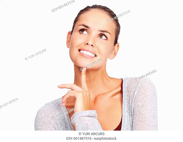 Closeup of happy young woman daydreaming with finger on chin on white background