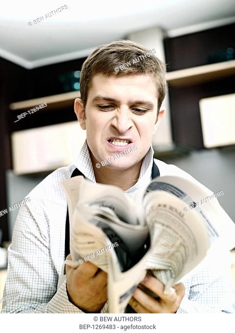 Angry man holding a newspaper