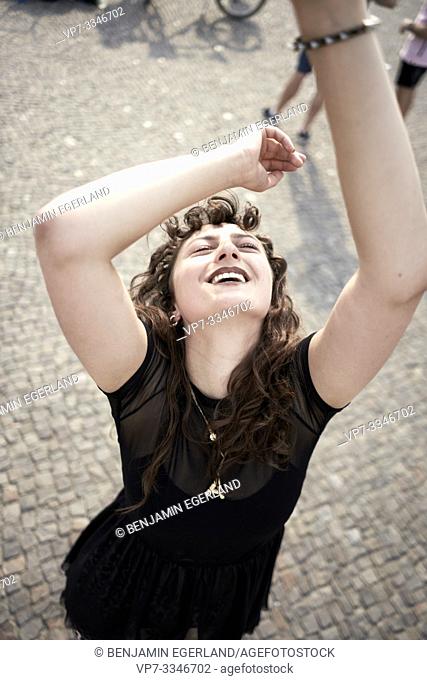 happy loose woman dancing on street in city Berlin, Germany