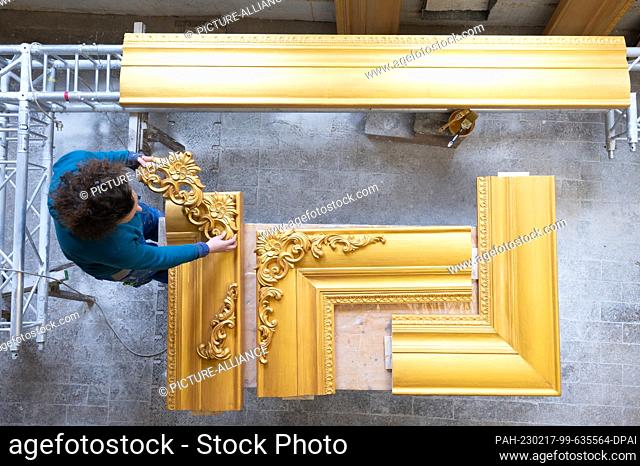17 February 2023, Saxony, Dresden: Anne Rauschenberg, theater sculptor, works on a golden frame in a workshop. The frame