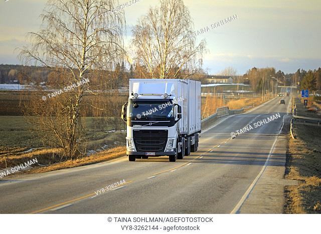 Salo, Finland - March 1, 2019: White Volvo FH truck double trailer for Posti Group, Finnish postal service on highway at sunset time in early spring