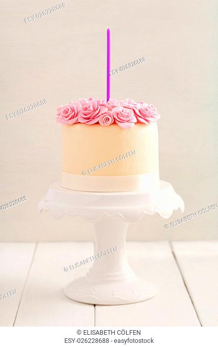 Ivory fondant covered cake with pink sugar roses on cake stand