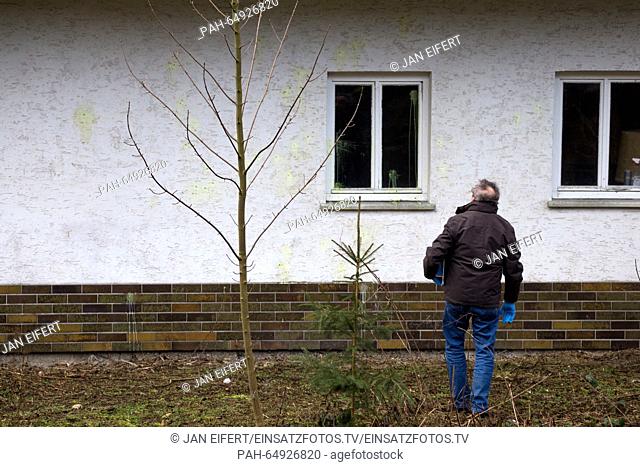A police officer examines the wall of a building which serves as an accommodation for refugees in Schmitten, Germany, 10 January 2016