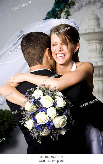 Close-up of a newlywed couple embracing each other and smiling