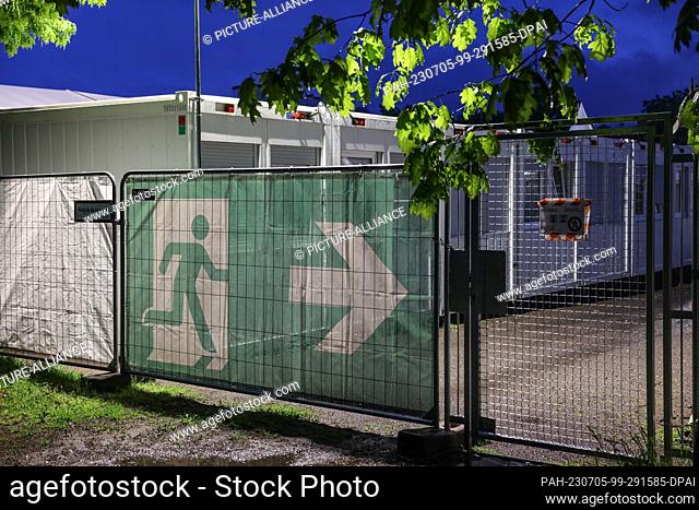FILED - 10 May 2023, North Rhine-Westphalia, Cologne: A banner with the symbol for the escape route hangs in front of housing containers at the municipal...