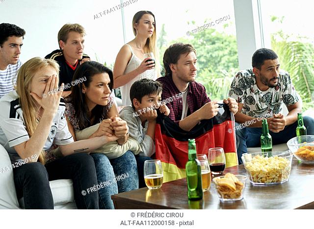 German football fans watching football match at home