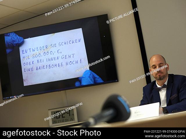 21 December 2023, Bavaria, Kempten: Martin Werobel, Chief Inspector of Criminal Investigation, sits at a press conference in front of a projection of a postcard...