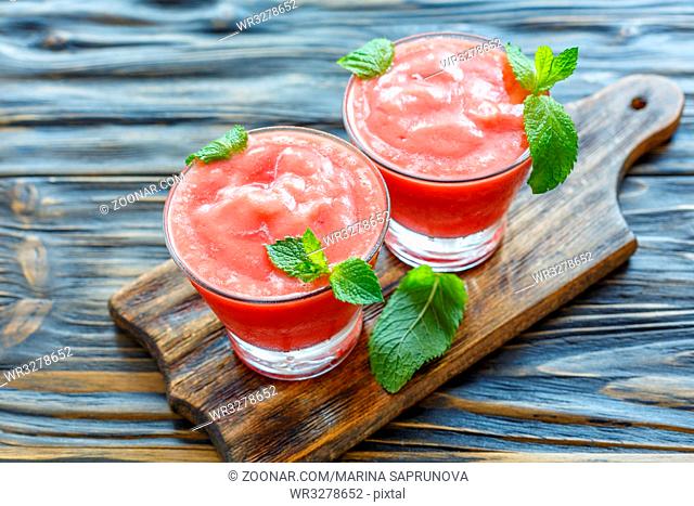 Watermelon smoothie in glasses on wooden table, selective focus