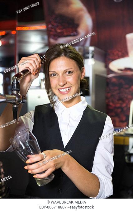 Happy barmaid pulling a pint of beer