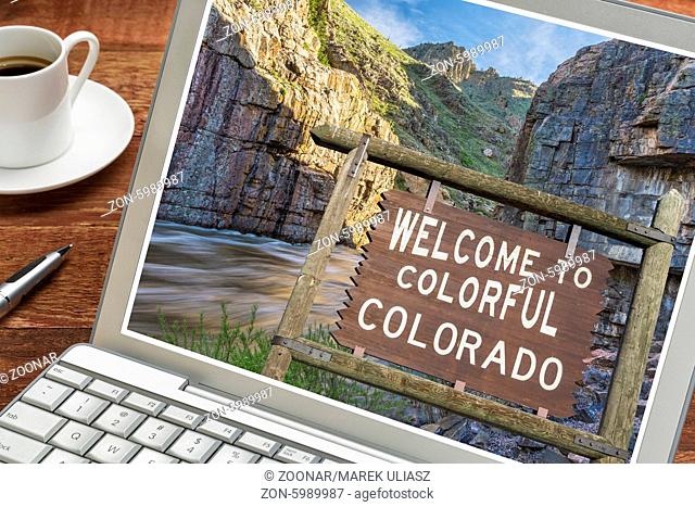 Colorado welcome sign on a laptop with a cup of coffee - planning vacations concept