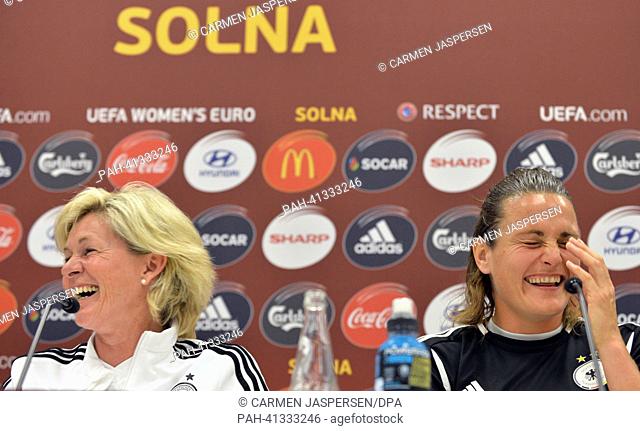 Germany's goalkeeper Nadine Angerer (R) and head coach Silvia Neid smile during the UEFA press conference at the Women's EURO in the press from of Friends Arena...