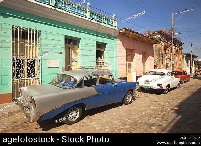Old American cars used as taxis in front of the colonial buildings at the historic center, Trinidad, Sancti Spiritu Province, Cuba, West Indies, Central America
