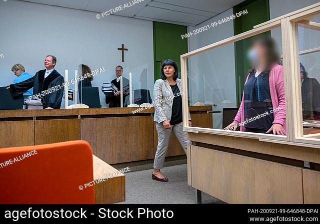 21 September 2020, Bavaria, Munich: The defendant (r) stands in her place in the courtroom before the start of the trial