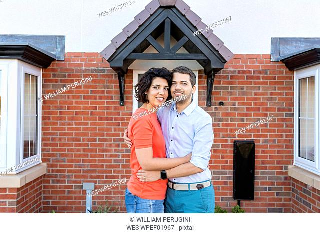 Portrait of happy couple in front of their new home