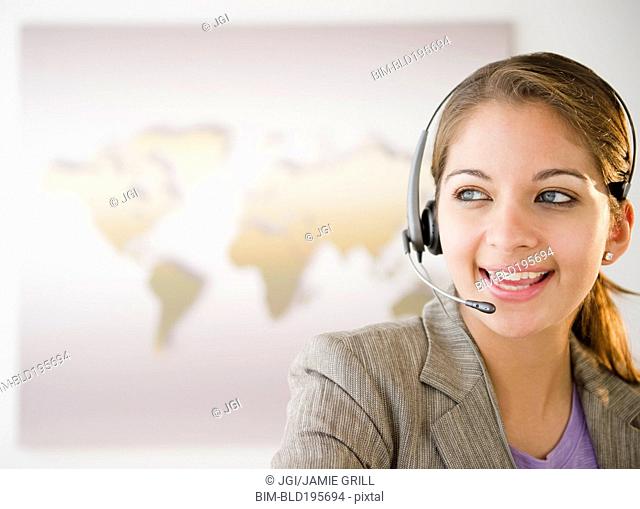 Indian businesswoman talking on headset in office