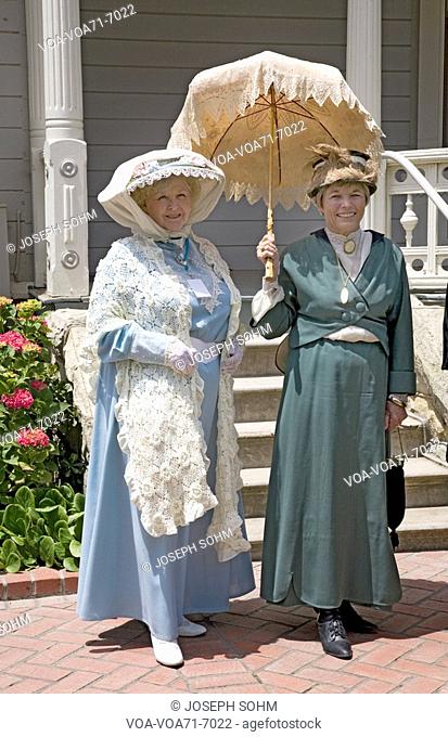Women in Victorian dresses standing on porch of Faulkner Farm and Victorian home in Santa Paula, CA