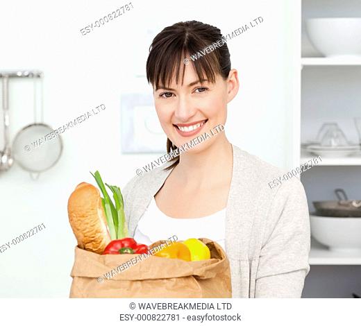 Woman with shoping bags in the kitchen at home