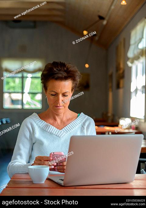 Portrait of mature beautiful woman with short hair relaxing inside coffee shop