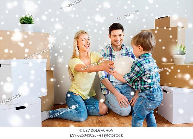 mortgage, people, housing, moving and real estate concept - happy family with boxes playing ball at new home over snow