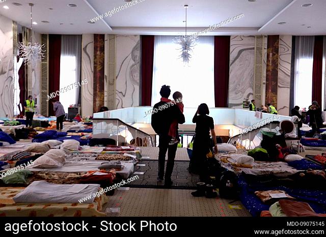 A Ukrainian father holds his daughter in his arms in the refugee reception room of the Mandachi Hotel. Suceava (Romania), March 7th, 2022