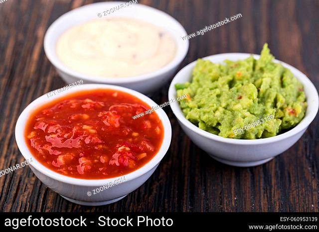 Bowls with sauces on white background
