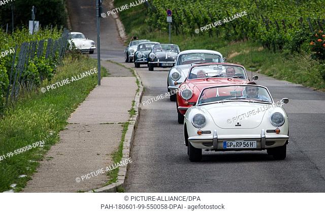 27 May 2018, Germany, Stuttgart: Old Porsches of the model 356 drive along a vineyard in a group. The company Porsche celebrates it 70th anniversary on 08 June