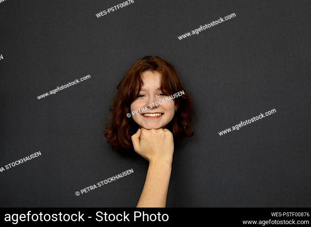 Studio shot of head of teenage girl leaning on male fist