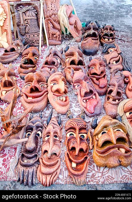 wooden carved funny masks sold in spring fair market. traditional rural crafts