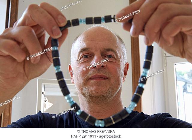 Goldsmith and designer of jewellery Hans-Peter Weyrich presents a black and green necklace just like the one German Chancellor Angela Merkel wore during the...