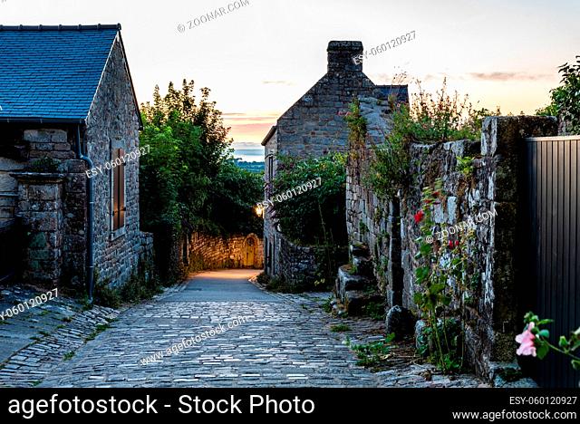 View of old street in the medieval village of Locronan at sunset
