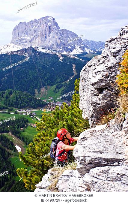Hiker on the Stevia fixed rope route in the Vallunga in Val Gardena, Dolomites, in the back Mt. Langkofel and the Sëlva village, South Tyrol, Italy, Europe