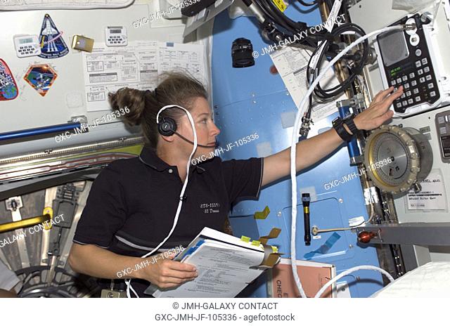 Astronaut Pamela A. Melroy, STS-112 pilot, uses a communication system in the Quest Airlock on the International Space Station (ISS)