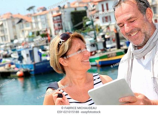Senior couple using digital tablet to find city tour