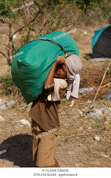A young boy carrying relief goods back home, Abra de Ilog, Mindoro Province, Philippines
