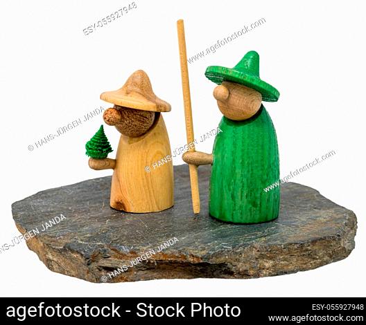 Two wooden christmas figure stand on a dark wooden board isolated on white